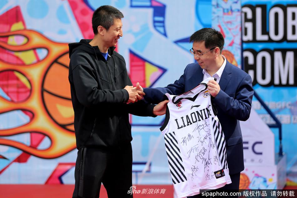 热情的沈阳球迷将郭士强团团围住,纷纷举起手中的球衣和篮球索要签名,郭士强低头认真为球迷签名。