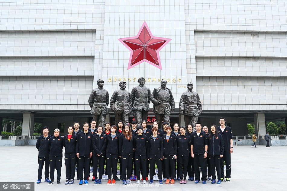 女篮队员们身着整齐的队服，在淮海战役纪念馆的大型浮雕前驻足仰望，神情庄重而专注，仿佛正与历史进行着一场无声的对话。