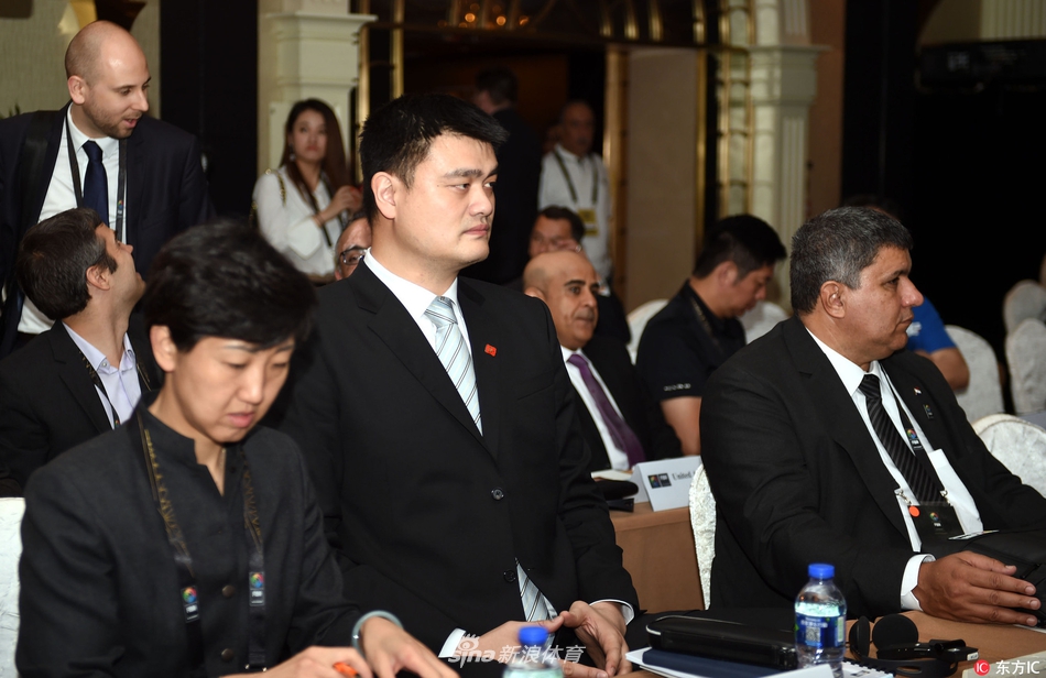 宏伟的香港会议展览中心内，国际篮联中期仝人大会现场灯火通明，来自世界各地的代表们齐聚一堂，身后巨大的国际篮联标志格外醒目，象征着全球篮球运动的团结与未来