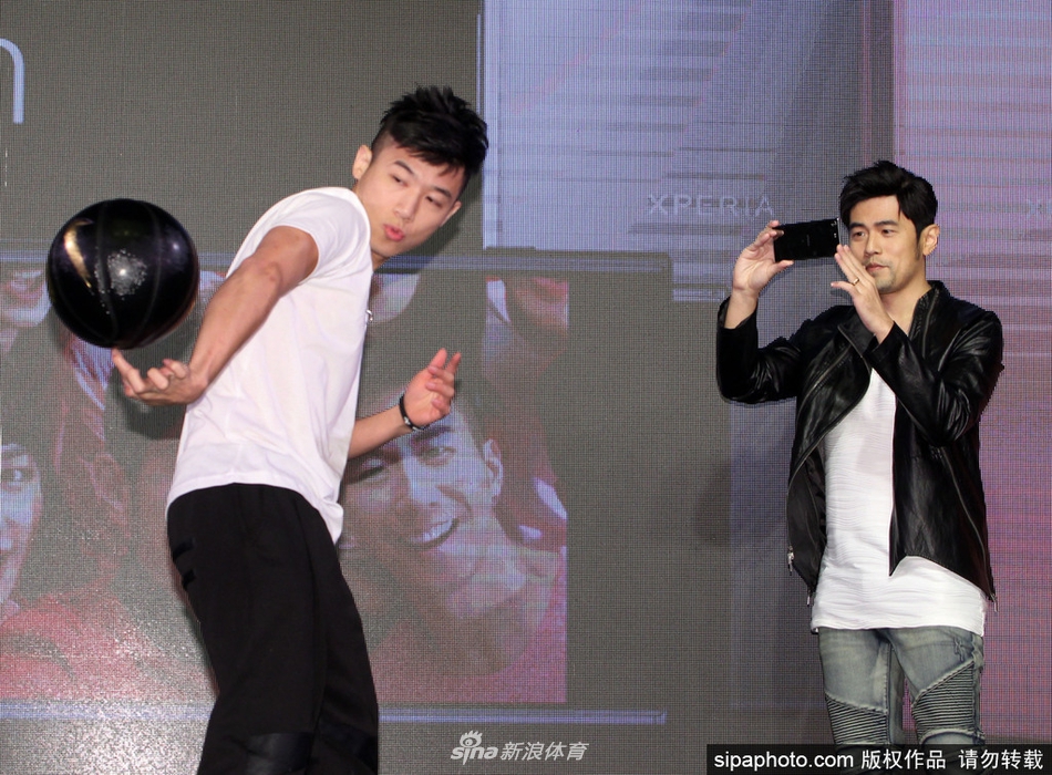 周杰伦聚精会神地盯着手中的篮球，正准备来一个花哨的胯下运球，动作虽不专业却颇具喜感。