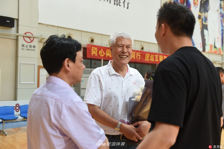 精神矍铄的蒋兴权指导身着简洁衬衫，步伐稳健地走出义乌车站，目光深邃地望向迎接的人群，开启了新的篮球征程。