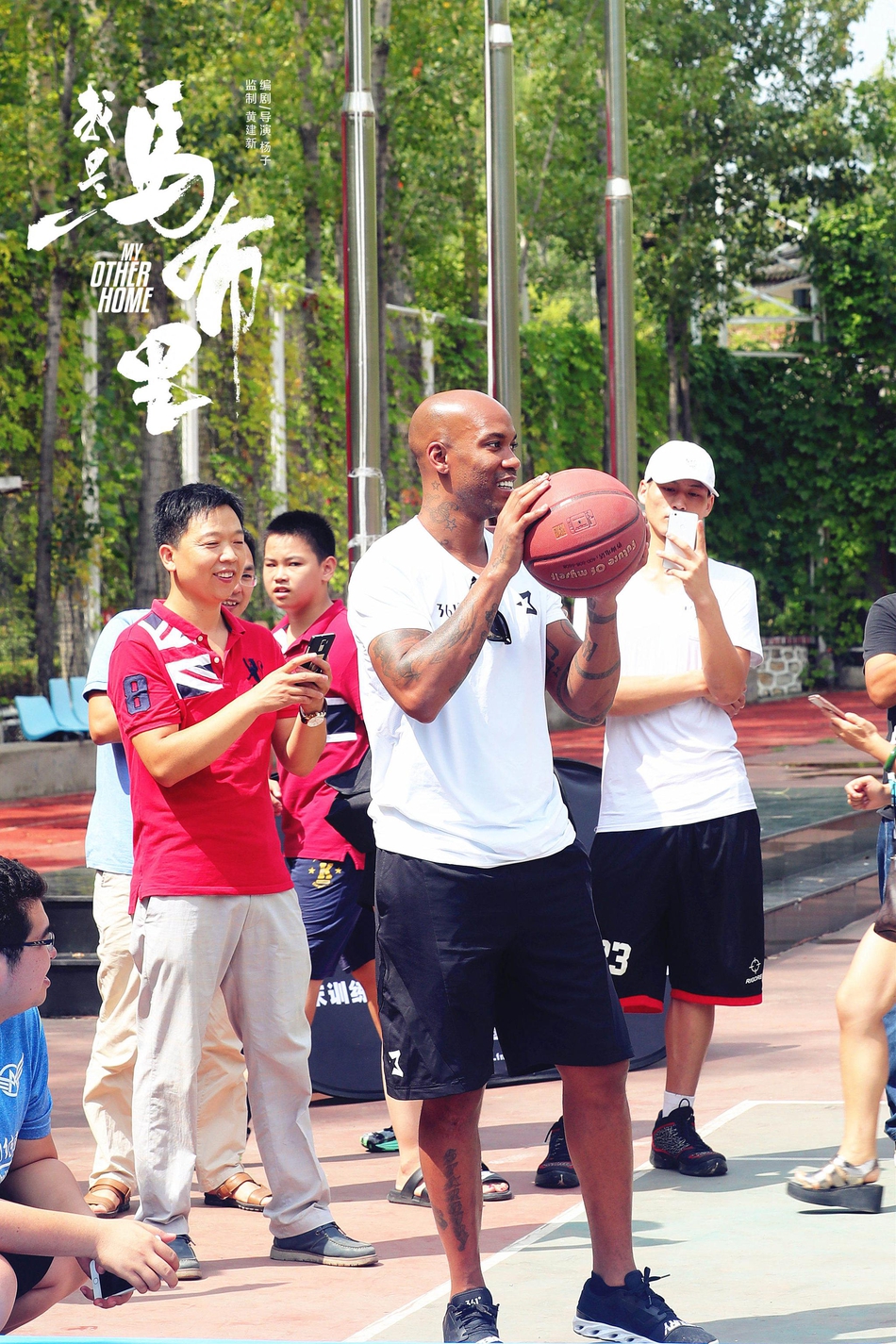 马布里身穿休闲装站在孩子们中间,脸上挂着慈父般的笑容,仿佛一位邻家大叔叔正准备给小朋友们上一堂别开生面的篮球课。