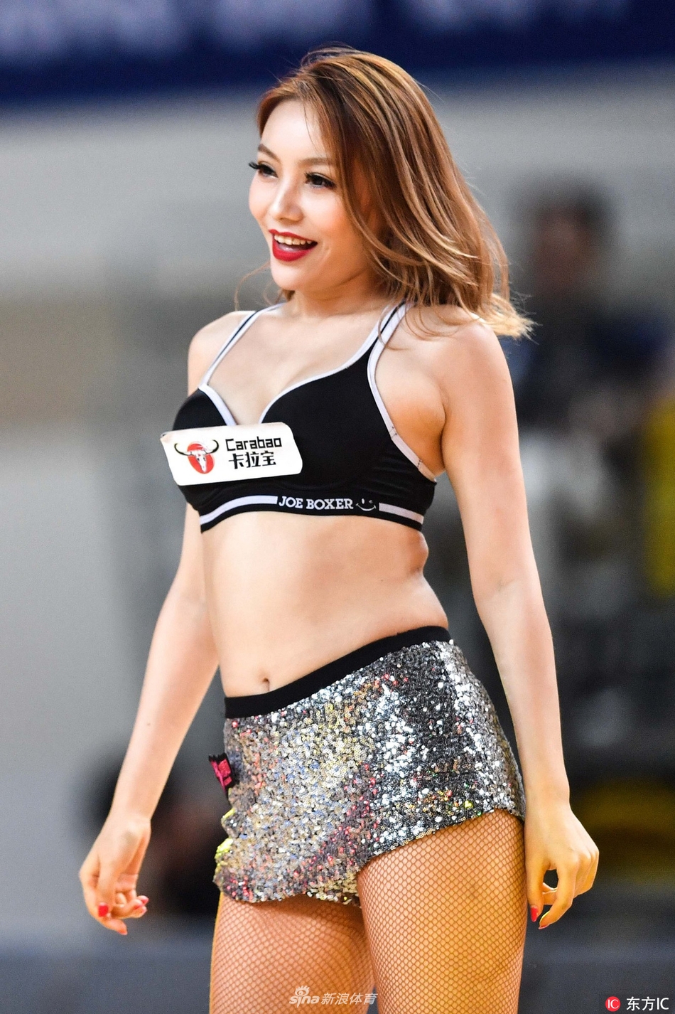 即使是静态的亮相，篮球宝贝们也姿态万千，她们单手叉腰，脸上洋溢着自信迷人的微笑，与身后巨大的赛事背景板相映成辉，定格下这美丽的瞬间。