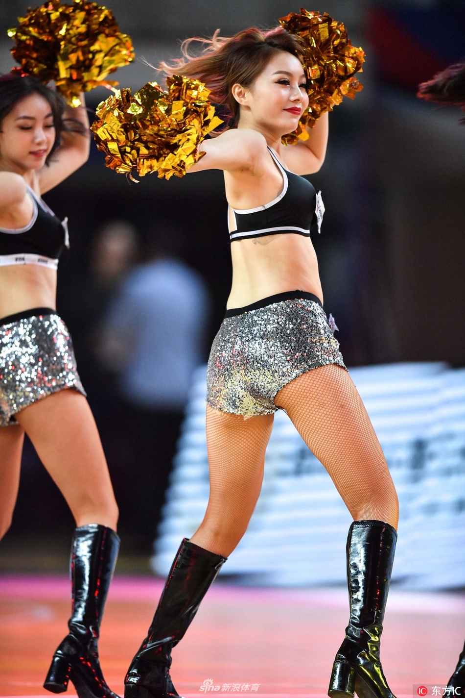 两位篮球宝贝背对背站立，侧身回眸看向镜头，一个俏皮地眨着眼睛，另一个则露出温婉的浅笑，展现出中国女孩灵动多变的独特魅力。