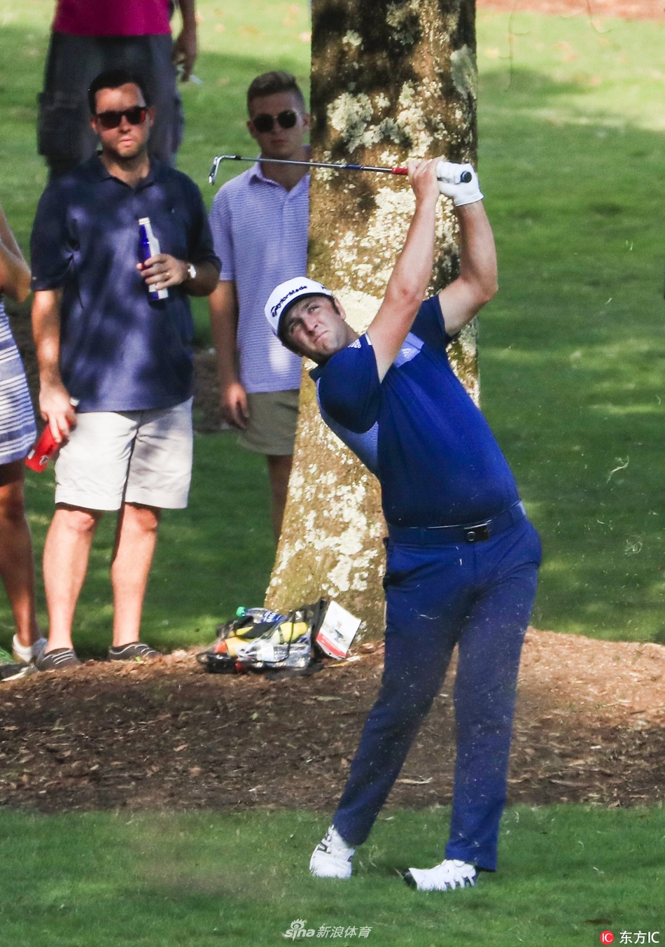 乔丹-斯皮思在全神贯注中完成一次关键的铁杆击球，身体挥杆姿态完美，背景是东湖球场标志性的景观