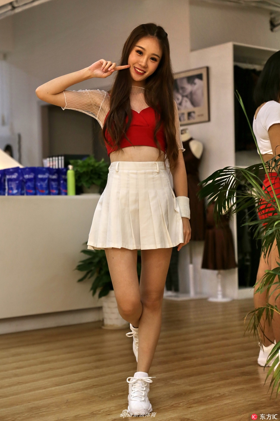 阳光透过树叶洒下斑驳的光影，篮球宝贝安静地倚靠在墙边，嘴角带着若有若无的笑意。简单的白T配短裙，却穿出了青春最动人的模样，清纯可爱得刚刚好。