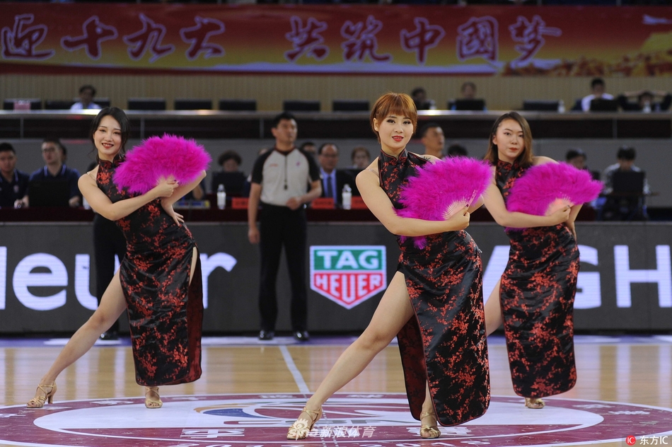 转身、甩袖、舒腕,宝贝们的动作整齐划一,粉色的旗袍裙摆随着舞动微微扬起,与背后的篮球架和记分牌构成一幅刚柔并济的独特画面。