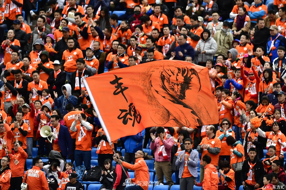 丰体中心激情一刻，北京人和外援阿约维在雨中与队友庆祝赛季收官胜利，背景是看台上热情洋溢的球迷。