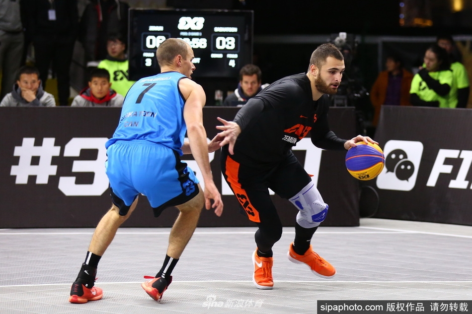 决赛瞬间，身穿红色球衣的泽蒙队球员博格丹·德拉戈维奇在对方严防死守下高高跃起，准备出手绝杀球，他身后巨大的FIBA三对三赛事logo和记分牌将现场紧张气氛烘托到顶点。