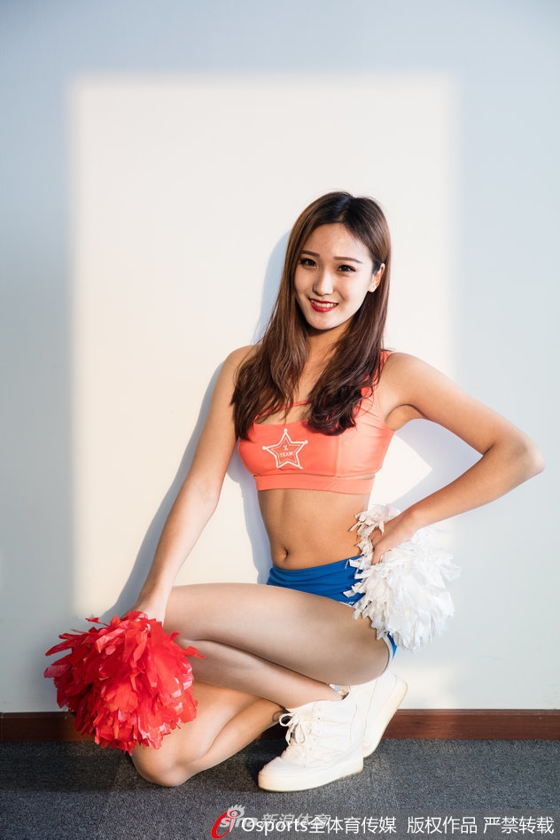 暖阳下的一抹紫金,长发飘飘的啦啦队员回眸一笑,发丝在光影中跳跃,仿佛将球场的热情带到了宁静的街角。