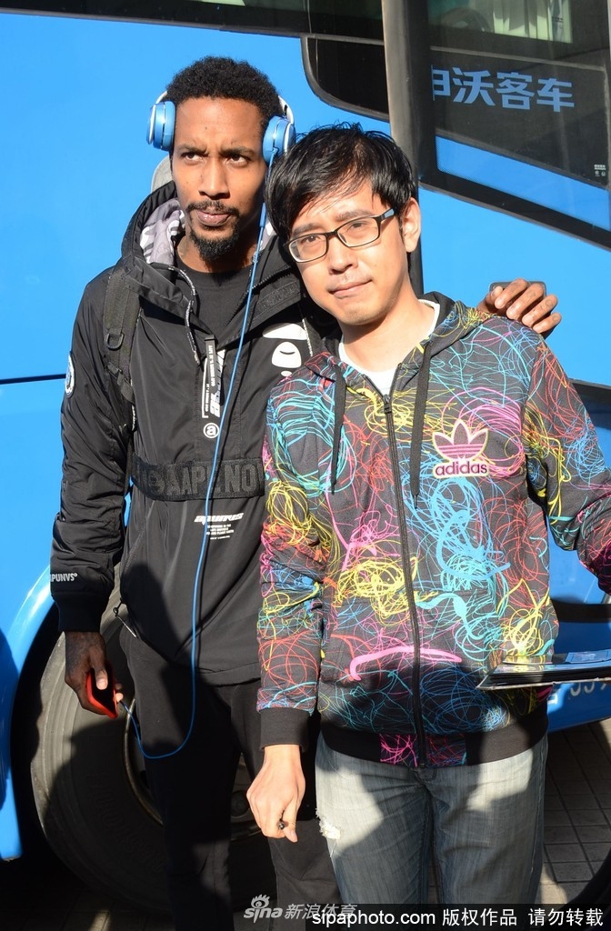 身披山西队战袍的詹宁斯刚走下大巴，便被热情的上海球迷团团围住，他微微低头，目光专注地在球迷递来的海报上签下自己的名字，举手投足间尽显NBA球星风范。