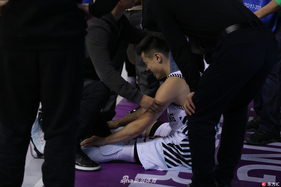 辽宁队医紧急入场查看伤情，赵继伟躺在地板上，眼神中充满了不甘与无奈。