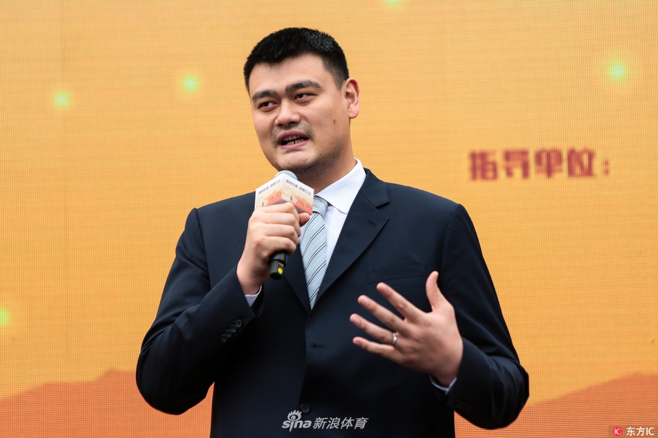 偌大的体育馆内，姚明站在台上，手拿话筒正在讲话，台下坐满了身穿校服的师生，大家的目光都聚焦在这位特殊的公益宣传大使身上，气氛庄重而热烈。