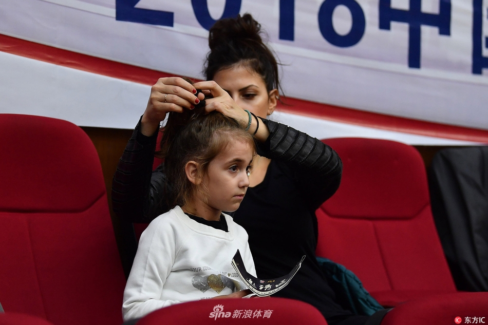 博洛西斯在妻女的注视下显得格外兴奋，他张开手臂试图干扰广东队的传球路线，脸上写满了专注与对胜利的渴望。