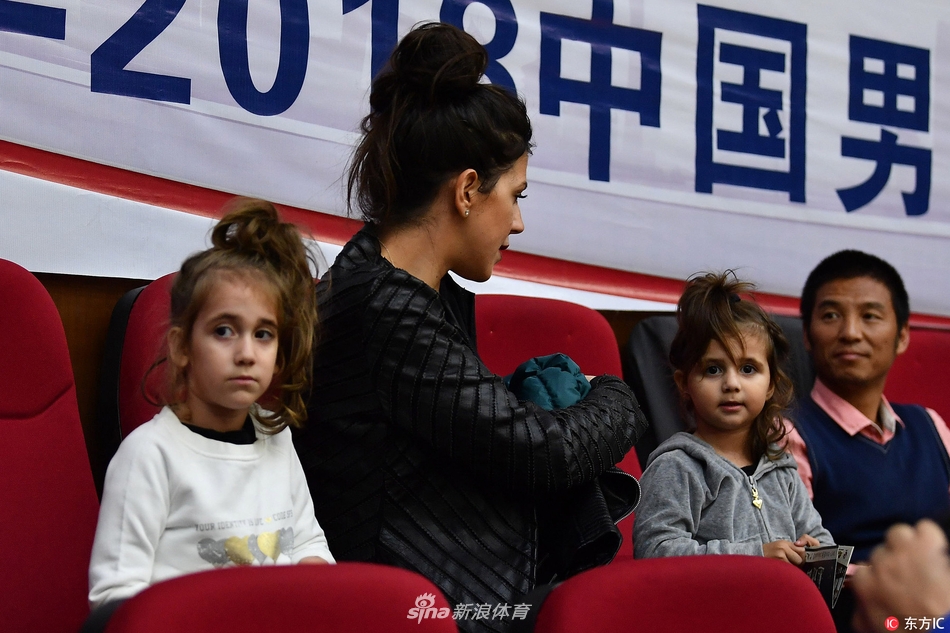 看台上的博洛西斯妻子手中抱着小女儿，大女儿则安静地依偎在她身旁，即便周围球迷情绪激昂，她们的目光始终温柔地锁定在场上那个高大的身影上。