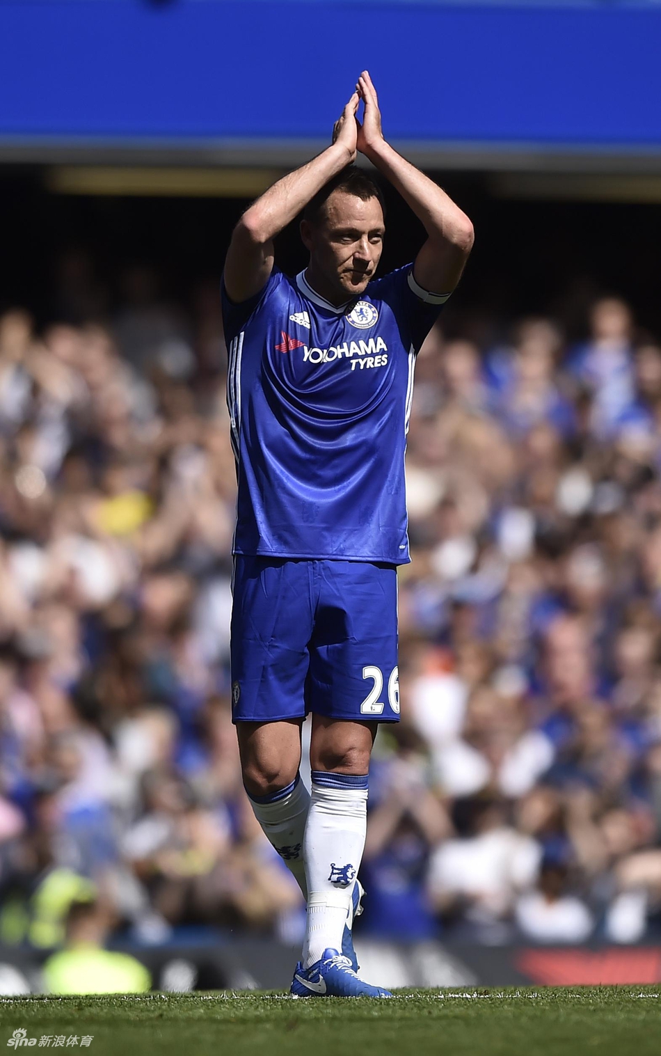 蒂埃里·亨利在海布里球场完成精彩进球后，双臂下垂摆出标志性的庆祝姿势，神态酷炫而骄傲，身后是阿森纳球迷举起的旗帜