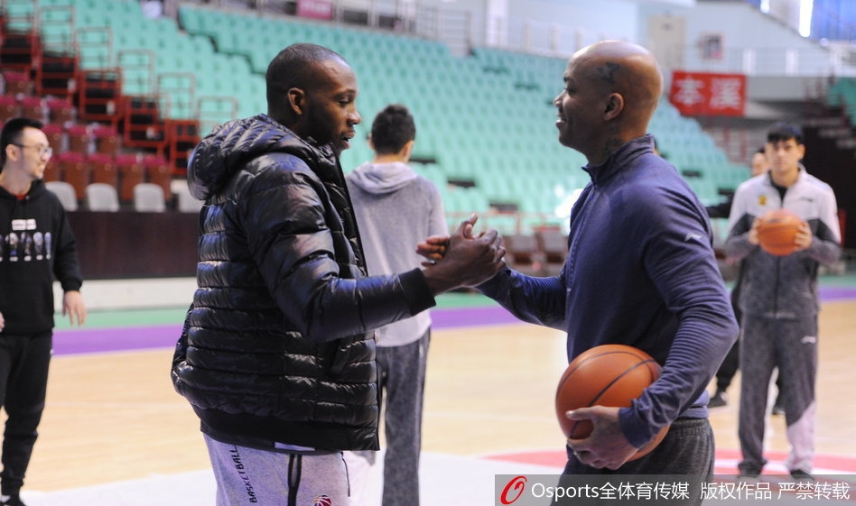 训练场上，哈德森露出标志性的憨厚笑容，马布里侧身与其交谈，两人身后的篮球架和队友构成背景，整个画面充满大战前夕难得的轻松与默契。