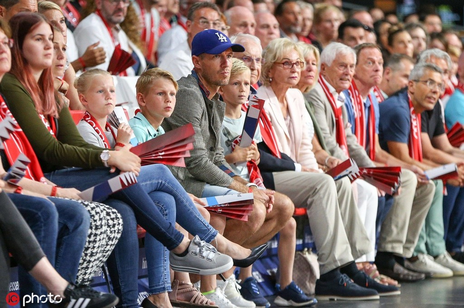 罗本微笑着与身旁的家人交谈，似乎在分享对比赛的看法，神情放松而愉悦