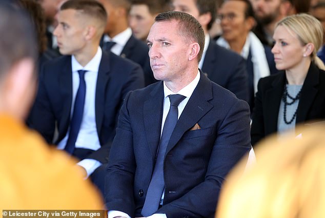 维猜纪念花园全景，一座充满泰式风情的纪念亭与莱斯特城主场相映成辉，花园内铺满了球迷敬献的蓝色鲜花和写满思念的卡片，庄严肃穆。