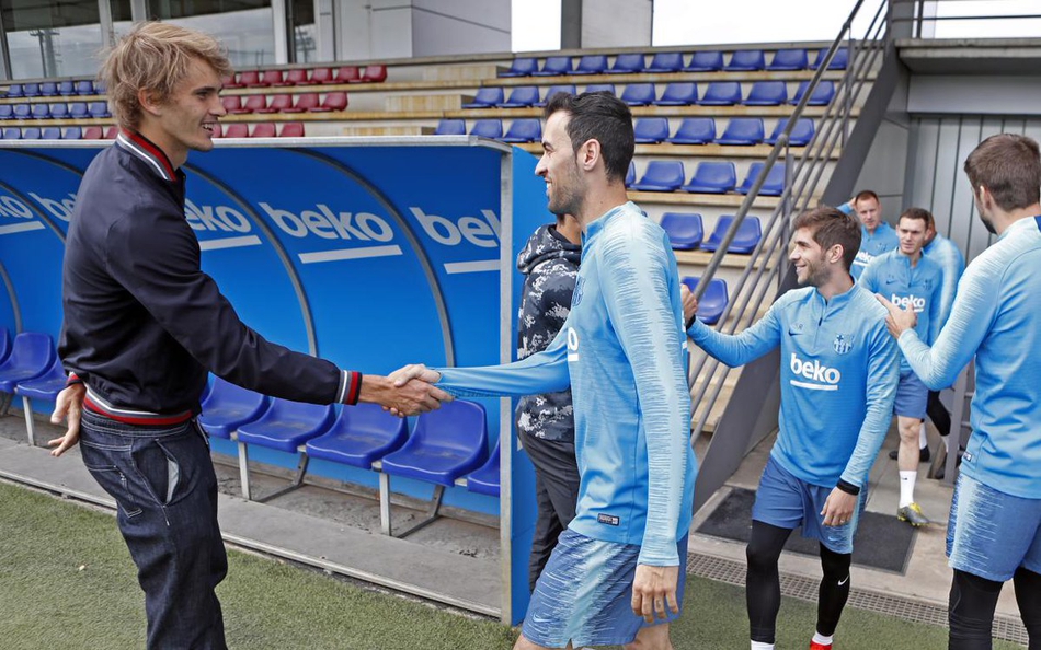 蒂姆与巴萨多名球员在训练场上集体合影，大家簇拥在一起，气氛如同老友聚会般热烈欢快