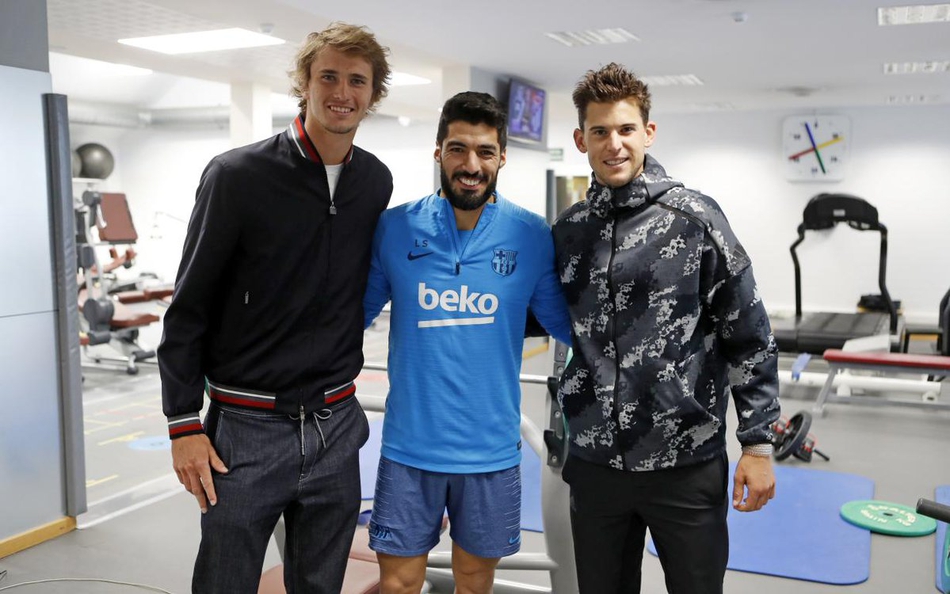 蒂姆与巴萨前锋苏亚雷斯并肩而站，对着镜头露出灿烂笑容，苏亚雷斯标志性的龅牙显得格外亲切