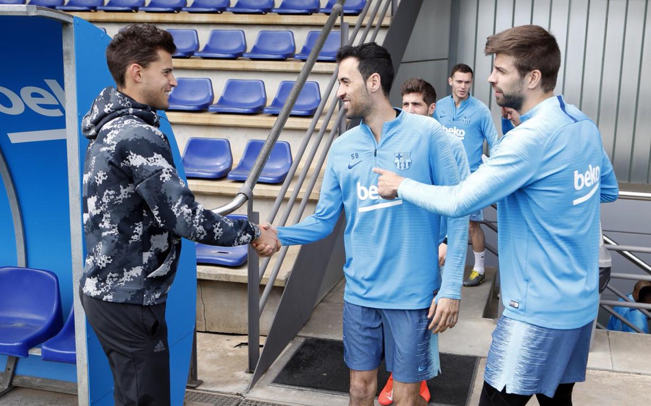 蒂姆在训练场边专注观看巴萨训练，脸上洋溢着对大牌球星们技艺的欣赏与赞叹