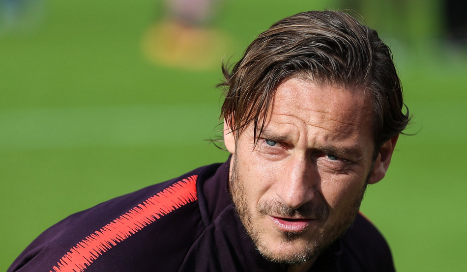 训练场上的托蒂，长发随风扬起，眼神专注而坚定，仿佛在凝视着自己为之奋斗一生的罗马城