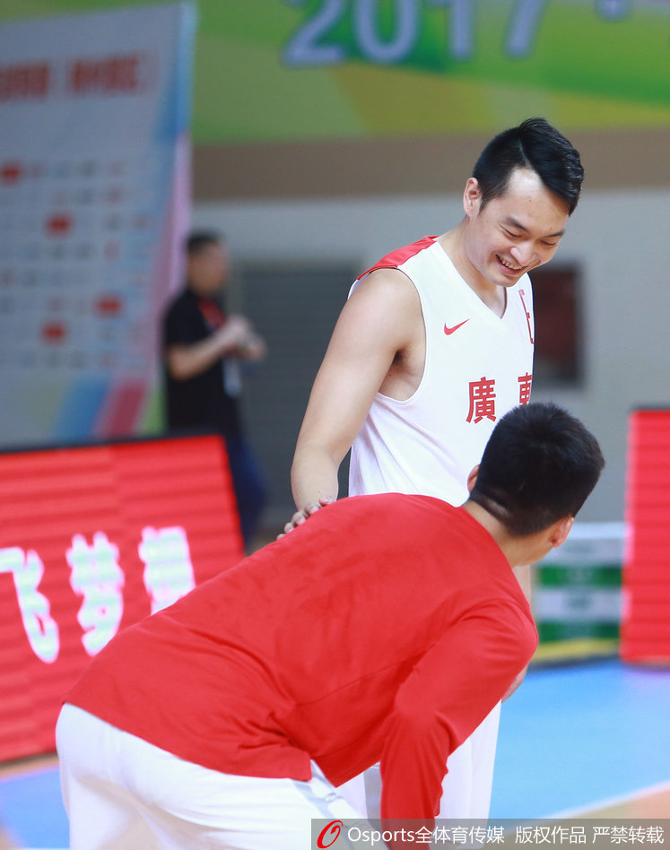 在热身场地的一角，老将朱芳雨与后卫陈江华低声交谈，两人神情轻松，嘴角带着笑意，仿佛对即将到来的大战早已成竹在胸。