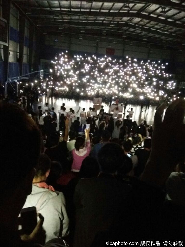 从球场高点俯瞰，手机灯光形成的星海环绕整个场馆，中央的球场轮廓被清晰照亮，场面壮观如一场精心策划的盛大演出