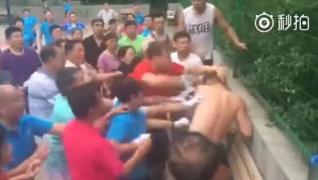 在围观群众的注视下,几名年轻人试图与情绪激动的大爷大妈们理论,肢体语言充满无奈与戒备,场面混乱不堪。