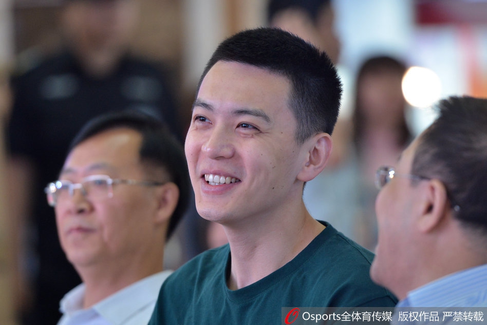 杨鸣在公益活动中手持篮球微笑，与身旁的女粉丝亲密互动准备投篮