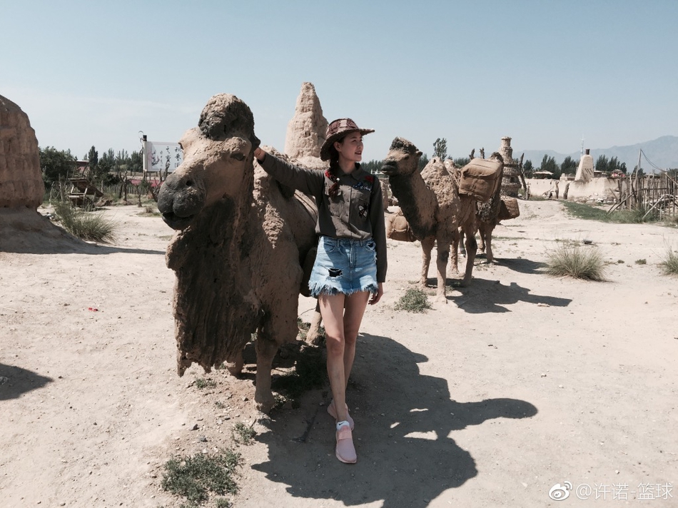 在电影《大话西游》的经典取景地前，许诺扎起马尾，身着黑色T恤和短裤，一条腿俏皮地微微弯曲，仿佛在与银幕中的故事对话，既有江湖儿女的豪气，又不失女孩子的俏皮。