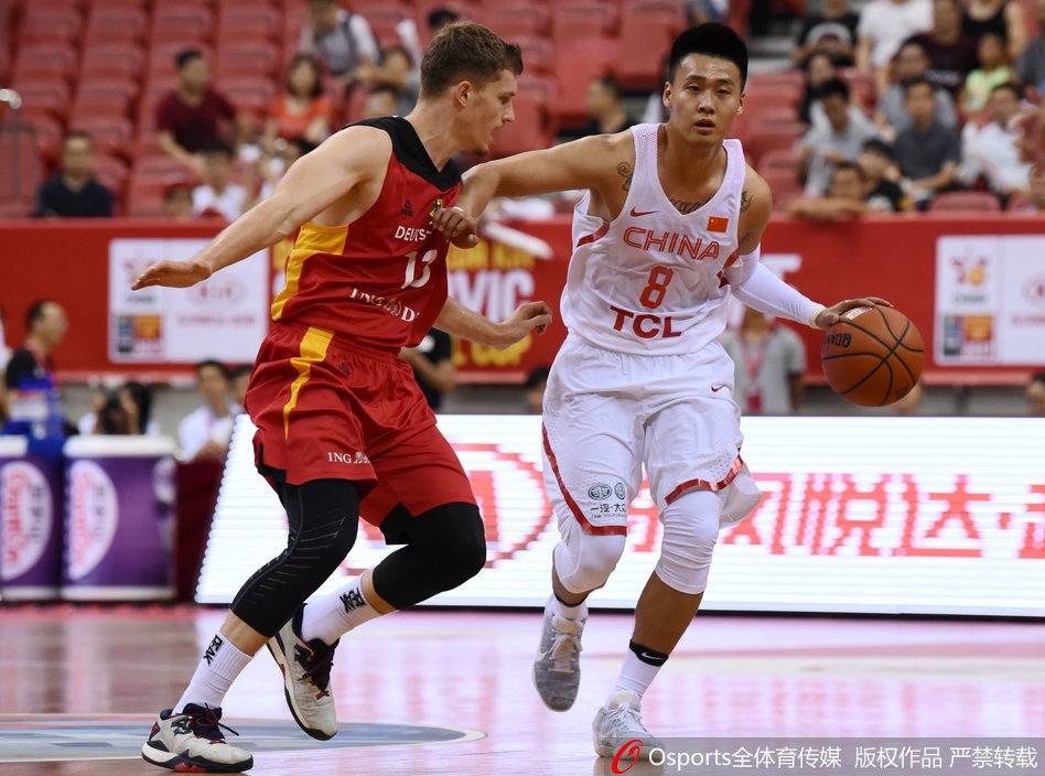 易立蹲在球员中间，手持战术板画着战术路线，队员们俯身低头认真聆听。