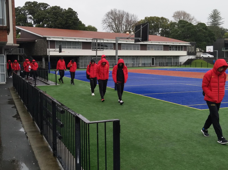 湿冷的空气中，身穿长款黑色棉服的男篮队员们在场边集结，呼出的白气与专注的眼神，构成了冬日训练场上最火热的画面。
