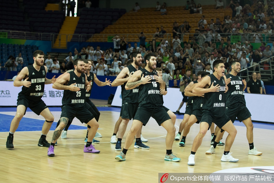 中国男篮蓝队的球员们站成一排,目光聚焦于对手的表演,神情专注而沉稳,虽然面对极具挑衅意味的舞蹈,但队员们保持了极高的职业素养和风度。
