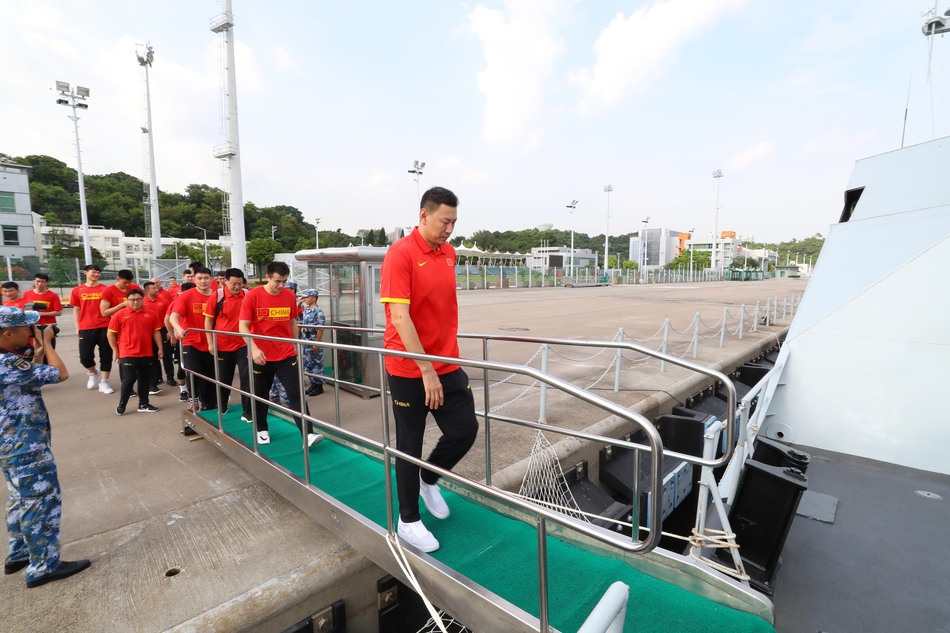 在热烈的掌声中,中国男篮红队副领队毛永强与驻港部队官兵代表交换象征荣誉与友谊的队旗,两支队伍的手紧紧握在一起,定格下军民团结的动人画面。