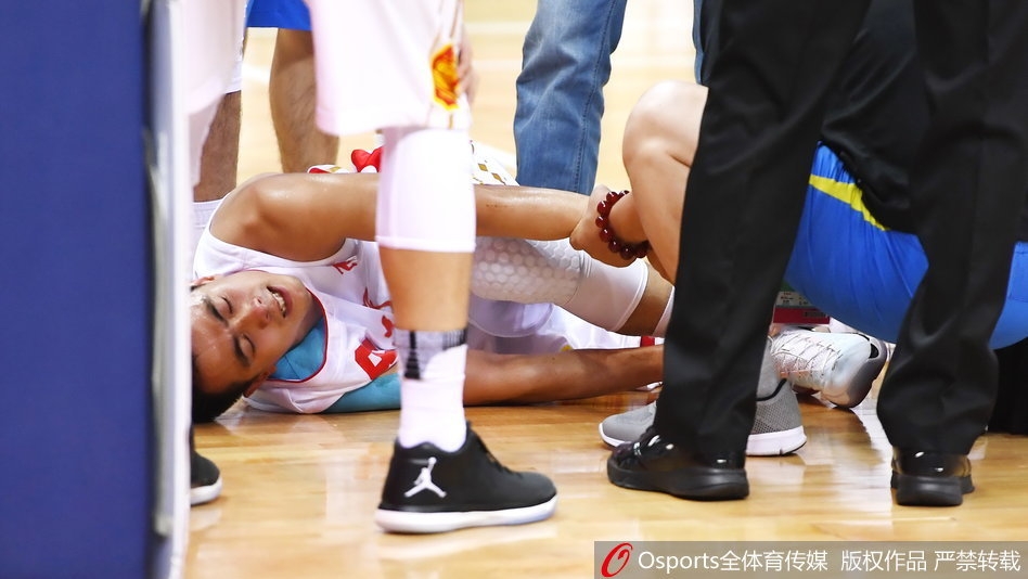 被抱到场边的赵继伟躺在蓝色的软垫上，左脚踝已经缠上了厚厚的冰袋进行紧急冰敷。他双眼望向赛场方向，眼神中满是对比赛的留恋和对自己伤情的担忧，队医则在一旁全程守护，密切关注着他的反应。