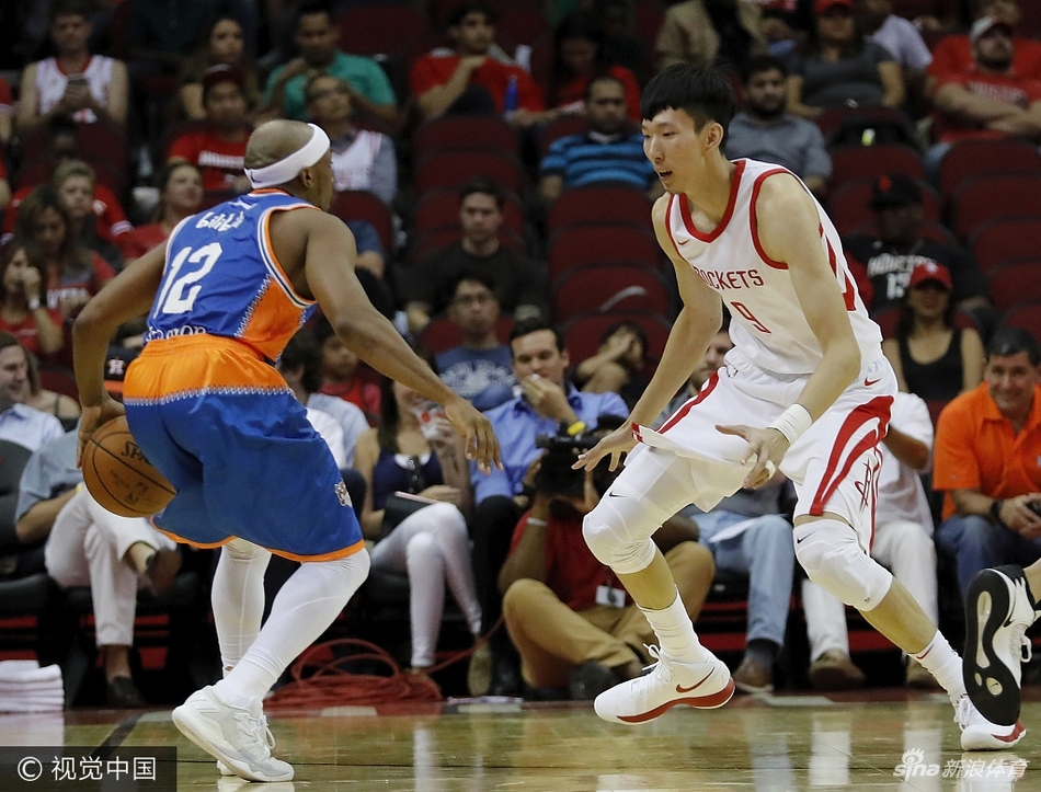 身披火箭战袍的周琦在防守端高高跃起，如同一座移动的高塔，用他惊人的臂展干扰了上海队的一次关键投篮。