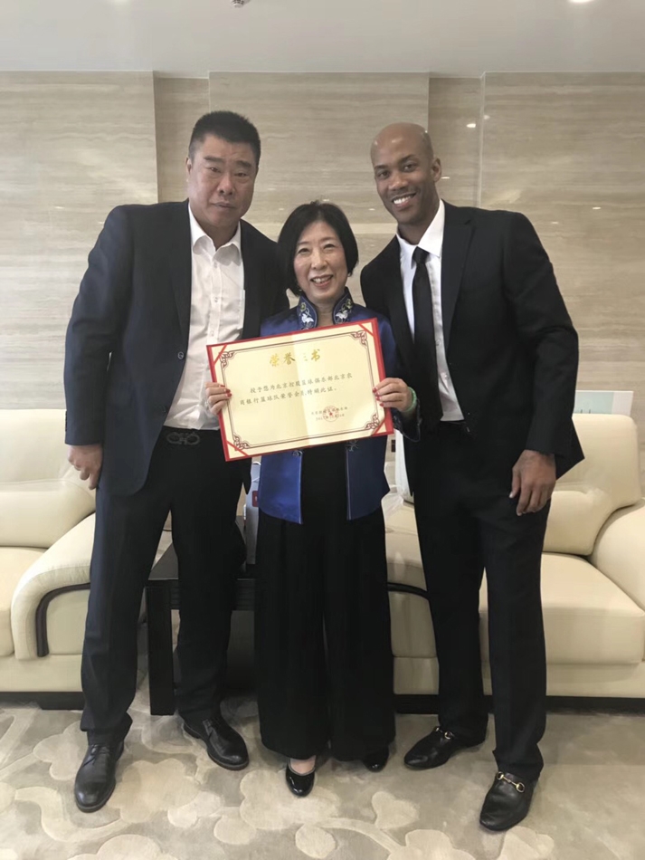 在摆满了荣誉奖杯和篮球的俱乐部背景板前，张阿姨接过北控俱乐部颁发的捐赠证书，她双手捧着证书，脸上露出了谦逊而满足的微笑。
