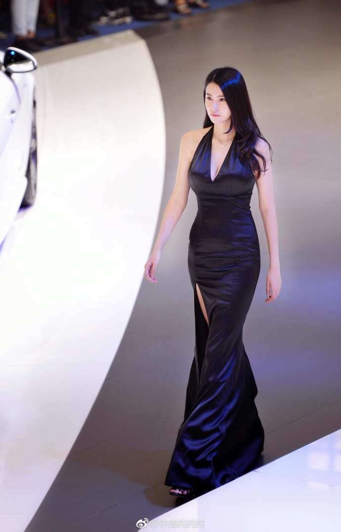 钟鹿纯身着一件简约的白色针织衫，搭配深色下装，随意地坐在台阶上，显得慵懒而惬意，散发着如同邻家大姐姐般的亲切与温柔气息。