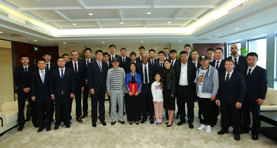 马布里与张阿姨及其家人并肩站在北控男篮的队徽前合影留念，每个人的脸上都绽放着灿烂的笑容，这一刻被镜头永久定格，成为京篮球坛又一段暖心记忆。