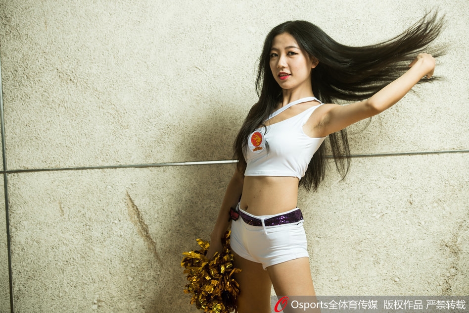 表演中，队员们排列成整齐的队形，动作整齐划一，手中的花球如同跳动的火焰，与背景中球员的剪影相映成趣。