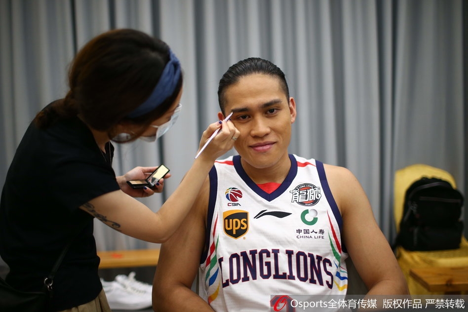 状元郎陈盈骏端坐在化妆镜前，化妆师为他打理发型，灯光下的每一根发丝都在诉说着一个新赛季、一个新希望在广州龙狮悄然萌芽。