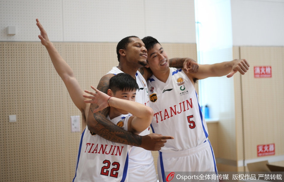 在一片蓝色的座椅背景前，队友们默契配合，在霍尔曼身后围成一圈，大家同时做出夸张的欢呼表情，仿佛在庆祝一场已经到手的胜利。