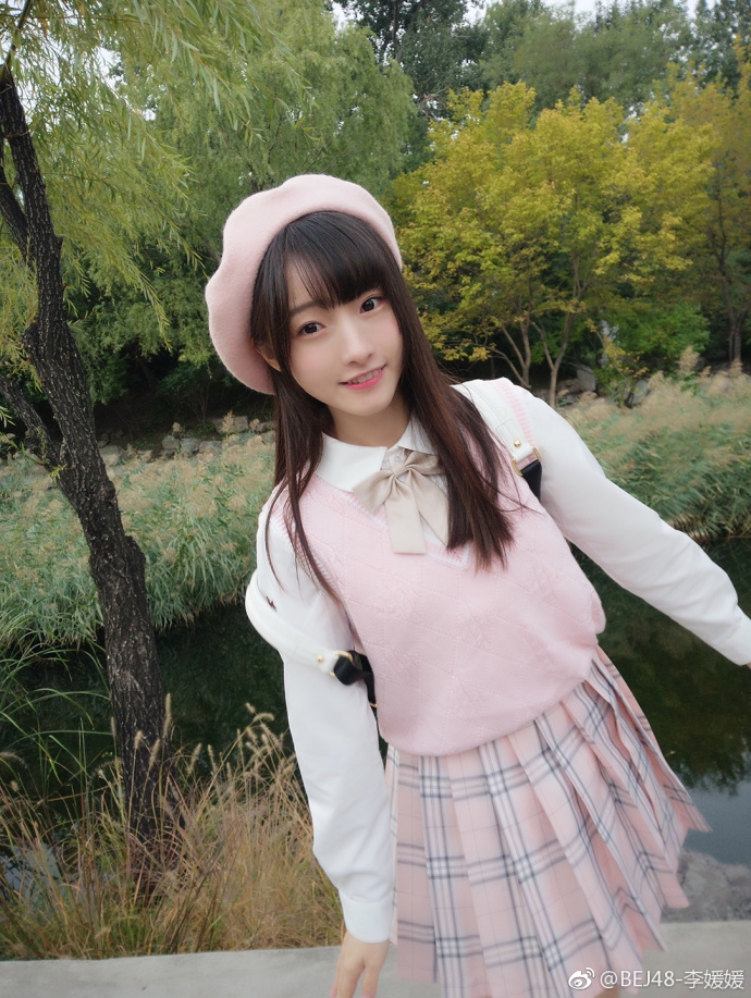 李媛媛专注地凝视前方，眼神中透露出对即将开始的激烈比赛的期待，仿佛在为场上的球员默默祈祷。