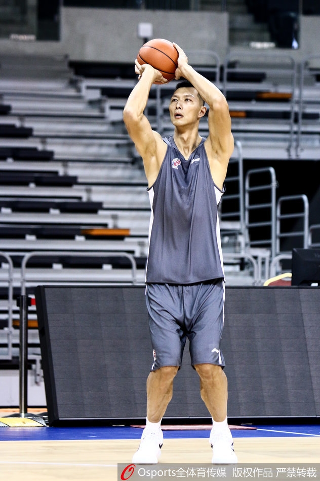 新任助教陈江华身着教练服，双手放在背后，目光如炬地注视着场上的训练情况，神情严肃而认真