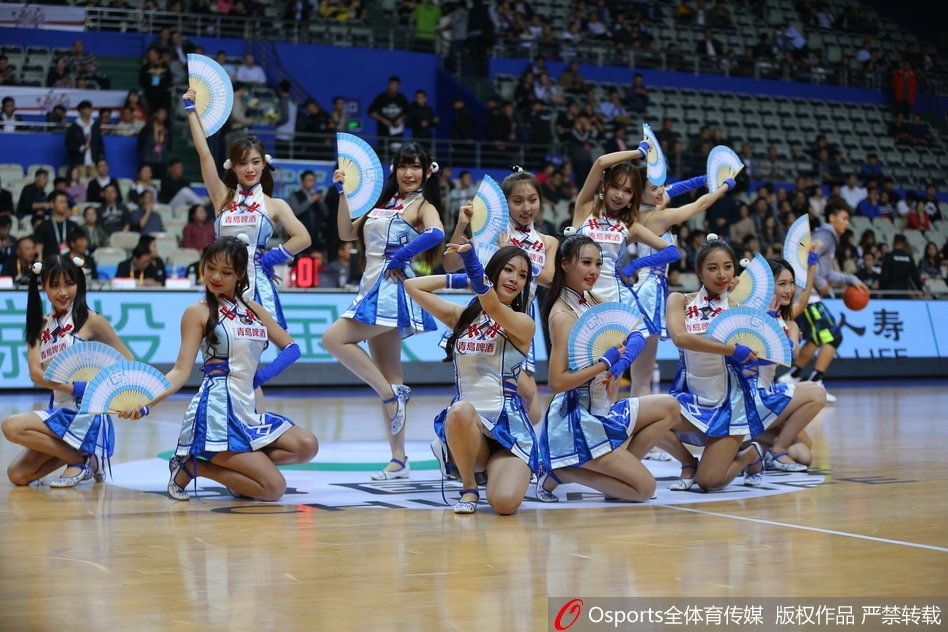 在队友的簇拥下，这位啦啦队员成为了绝对的焦点。她微微侧身，对着镜头送出飞吻，眼神迷离而又充满诱惑。粉色的舞裙随着她的动作轻轻摆动，将少女的甜美与成熟的妩媚完美融合，令人过目难忘。