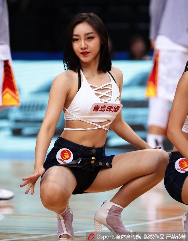 身姿挺拔的她目光坚毅地望向远方，修长的身形在灯光下勾勒出优美的线条，举手投足间散发着自信的魅力。