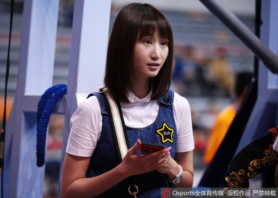 刘美不经意间的回眸，长发披肩，眼神清澈而坚定，牛仔短裙下的一双美腿在球场灯光下显得格外修长，成为场边一道流动的风景。