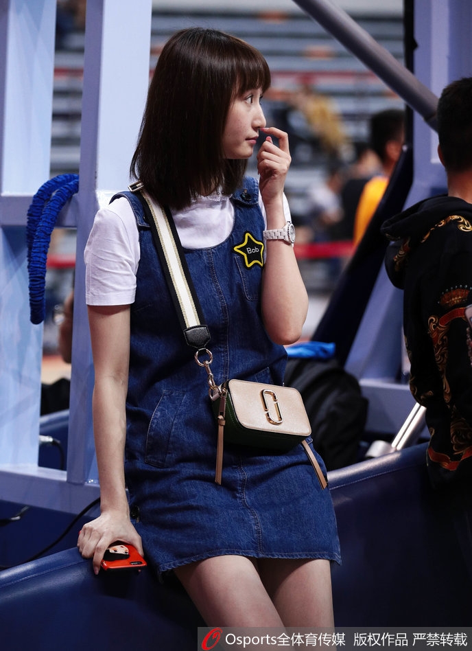 镜头拉近，刘美五官精致，嘴角带着浅浅的笑意，牛仔裙勾勒出她纤细的腰肢，即便在人群中，她的气质也格外引人注目。